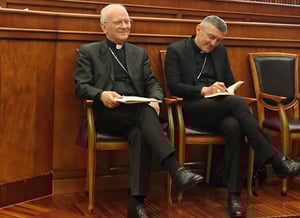 Due vescovi prendono appunti durante il convegno.