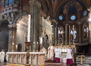 Celebrazione davanti all’altare maggiore, con candele accese.