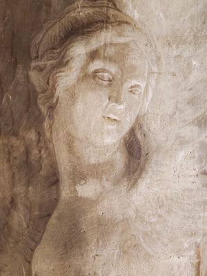 Dettaglio di affresco monocromo: volto femminile con sguardo abbassato, capelli mossi; intonaco usurato con segni del tempo