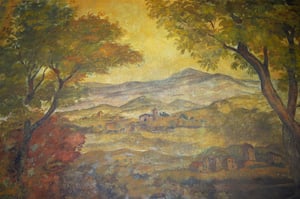 Affresco che rappresenta un paesaggio bucolico con alberi dalle chiome verdi e giallo-arancio, un villaggio collinare con edifici in pietra e una chiesa sullo sfondo; tonalità calde e vivaci che richiamano l’atmosfera autunnale