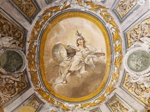 Affresco su volta con al centro una figura femminile allegorica seduta, coronata e con scudo e scettro, incorniciata da ghirlande dorate. Attorno, numerosi putti bianchi in rilievo e quattro medaglioni verdi con scene mitologiche e guerriere