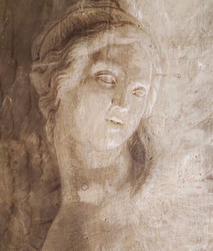 Dettaglio di affresco monocromo: volto femminile con sguardo abbassato, capelli mossi; intonaco usurato con segni del tempo